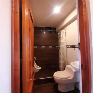 a bathroom with a toilet and a shower at LAGUNA HOUSE in Huaraz
