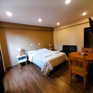 1 dormitorio con 1 cama grande y escritorio en LAGUNA HOUSE en Huaraz