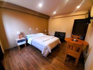 a bedroom with a large bed and a table at Laguna House in Huaraz