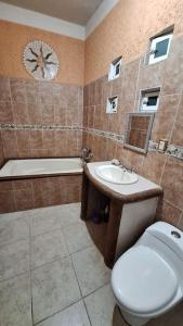 ein Badezimmer mit einem WC, einem Waschbecken und einer Uhr in der Unterkunft Casa Completa con Alberca, Sola, 3 habitaciones AC, Atras del Balneario Agua Hedionda totalmente Privada in Cuautla Morelos