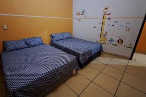 2 Betten in einem Zimmer mit blauen Bettdecken in der Unterkunft Casa Completa con Alberca, Sola, 3 habitaciones AC, Atras del Balneario Agua Hedionda totalmente Privada in Cuautla Morelos