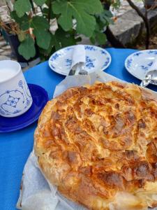 a pie on a blue table with plates and a cup at DOLCE NOTTE rooms in Virpazar +22 photos