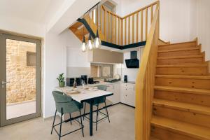 a kitchen with a table and chairs and a staircase at Anadia Luxury Pocket Villa in Falasarna