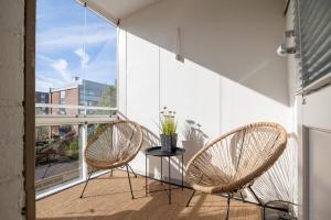 a balcony with two chairs and a table with flowers at Ydinkeskustan designkaksio in Hämeenlinna