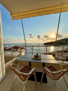 una mesa y sillas en el balcón de un barco en Fane's Apartments en Himare