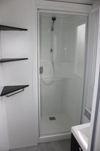 a shower with a glass door in a bathroom at Mobil-home in Litteau