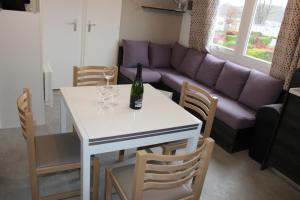 a living room with a white table and a couch at Mobil-home in Litteau +2 photos