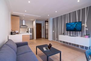 a living room with a blue couch and a kitchen at Ninel Home Tenerife in Palm-mar