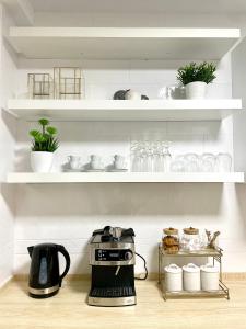 The HAVEN Apartment في بونفيراذا: آلة صنع القهوة على منضدة المطبخ مع الرفوف