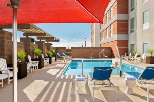 a pool on the rooftop of a hotel with chairs and an umbrella at Tru By Hilton Scottsdale Salt River in Scottsdale