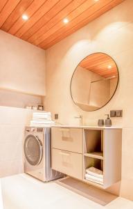 a washer and dryer in a bathroom with a mirror at City Panorama with SAUNA in Tartu +13 photos
