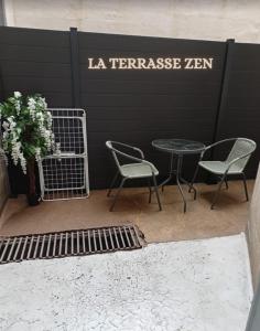 2 chaises et une table avec un panneau mural dans l'établissement La Terrasse Zen DACHER - Superbe appartement 30 m2 tout équipé avec terrasse cœur Vichy proche gare Thermes Cures, à Vichy