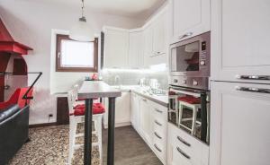 eine Küche mit weißen Schränken und einer Mikrowelle in der Unterkunft Casa Annita in Naggio