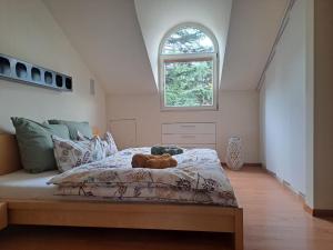 Un dormitorio con una cama con un osito de peluche. en Mansarde Zeder in Privatvilla im Zentrum Merans, en Merano