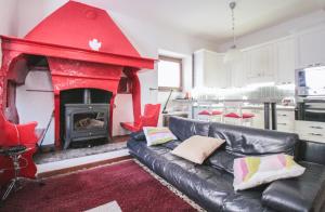ein Wohnzimmer mit einem schwarzen Sofa und einem roten Kamin in der Unterkunft Casa Annita in Naggio