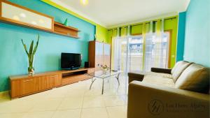 a living room with a couch and a tv at Alegria - Shopping Center 150m - Pool - Parking - Terrace in Portimão