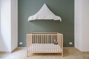 Una cuna blanca con una tienda de campaña colgando sobre ella en Italianway - Mazara City Center Family Apartments, en Mazara del Vallo