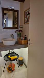 bagno con lavandino, specchio e tavolo di Affittacamere Leoncorno Ferrara a Ferrara