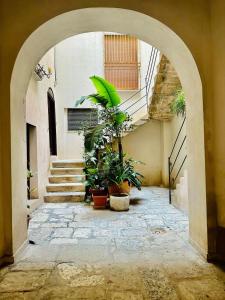 an archway with potted plants and stairs in a building at San Lorenzo Room in Trapani