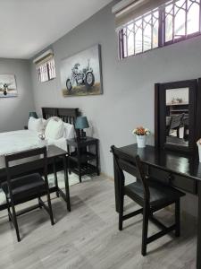1 dormitorio con cama, escritorio y mesa en Gabriel's Gate, en Johannesburgo