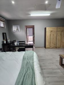 1 dormitorio con 1 cama y comedor con mesa en Gabriel's Gate, en Johannesburgo
