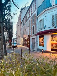 uma rua da cidade com edifícios e um carro na estrada em L'escale Versailles paris G/W/N em Versailles