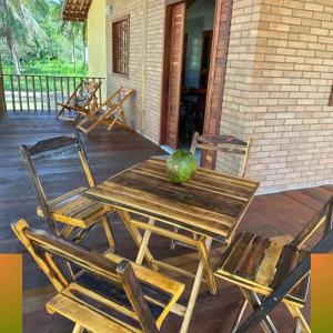 una mesa de madera y sillas en un porche en Glamping Bio-Dorf Casa 4 en Trairi