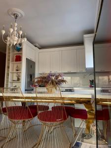 a kitchen with a table with chairs and a chandelier at Besa Apartment in Tirana