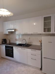 a white kitchen with a sink and a refrigerator at Lavanda in Mali Lošinj