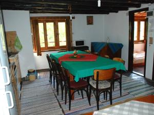 a dining room with a green table and chairs at Guest House Four Pines in Beli Osŭm