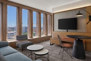 a living room with a couch and a table and some windows at Sheraton Denver Downtown Hotel in Denver