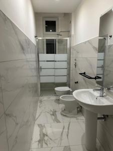 uma casa de banho branca com um WC e um lavatório em Jcube Apartments Bocconi Milano em Milão