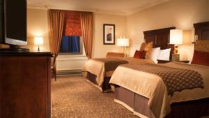 a hotel room with two beds and a flat screen tv at Omni William Penn Hotel in Pittsburgh