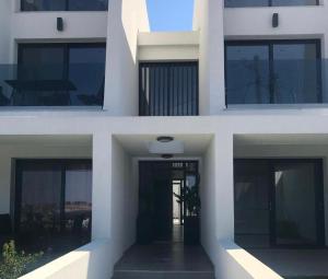 trzy różne widoki na biały budynek z oknami w obiekcie Kallithea love paradise pool & garden w mieście Kallithea