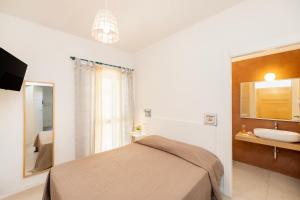 a bedroom with a bed and a sink at Aria di Mare Vieste - Luxury Apartments by the Sea in Vieste