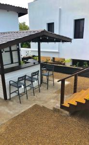une terrasse avec 2 chaises, une table et des bancs dans l'établissement Samudra Villas 2, à San Pedro