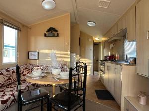 uma cozinha e uma mesa num quarto com um sofá em CaSa VistA - Holiday Home On The Beach em Clacton-on-Sea