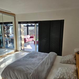 1 dormitorio con 1 cama y puerta corredera de cristal en Casa33 en Bornem