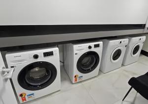 uma fila de máquinas de lavar roupa sentadas sob um balcão em Flat Home Business 202 Centro Pomerode em Pomerode