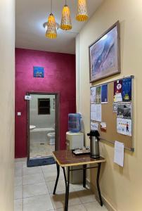 a room with a table in front of a bathroom at Al-Amer Hostel 1 in Aqaba