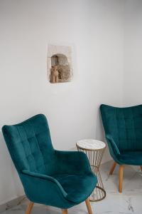 - deux chaises vertes et une table dans une pièce dans l'établissement Porto Vecchio, à La Canée