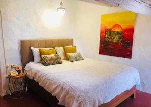 a bedroom with a bed with a painting on the wall at Casa Medieval by NaturAlegre in Alegrete