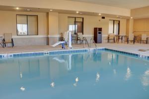 una gran piscina con sillas y mesas en un hotel en Holiday Inn Express Hotel & Suites Texarkana East, an IHG Hotel, en Texarkana