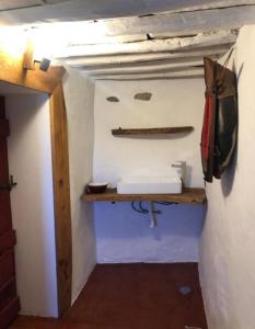 a bathroom with a sink and a shelf on the wall at Casa Medieval by NaturAlegre in Alegrete