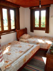 two beds in a room with two windows at Guest House Four Pines in Beli Osŭm