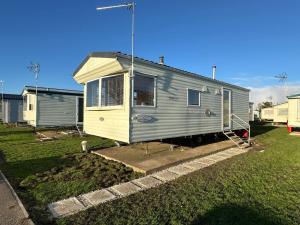 una casa pequeña está estacionada en un patio en CaSa VistA - Holiday Home On The Beach en Clacton-on-Sea