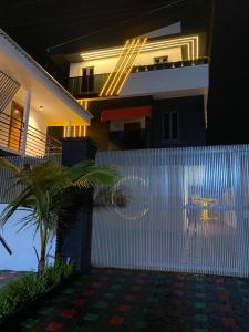 a white fence in front of a house with a palm tree at PROOF RESIDENCE in Lekki