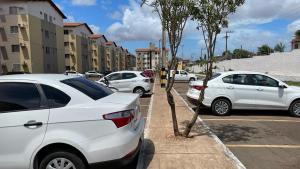 Une rangée de voitures blanches garées dans un parking dans l'établissement Apto bem localizado est de Ribamar ao lado do shopping, à São José de Ribamar