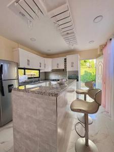uma cozinha com um balcão e cadeiras em Villa Alexa em La Cana