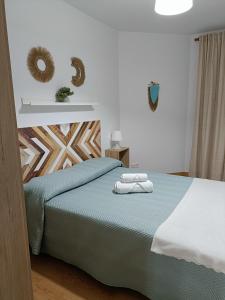 ein Schlafzimmer mit einem Bett mit zwei Handtüchern darauf in der Unterkunft Apartamento La Planchada in El Astillero